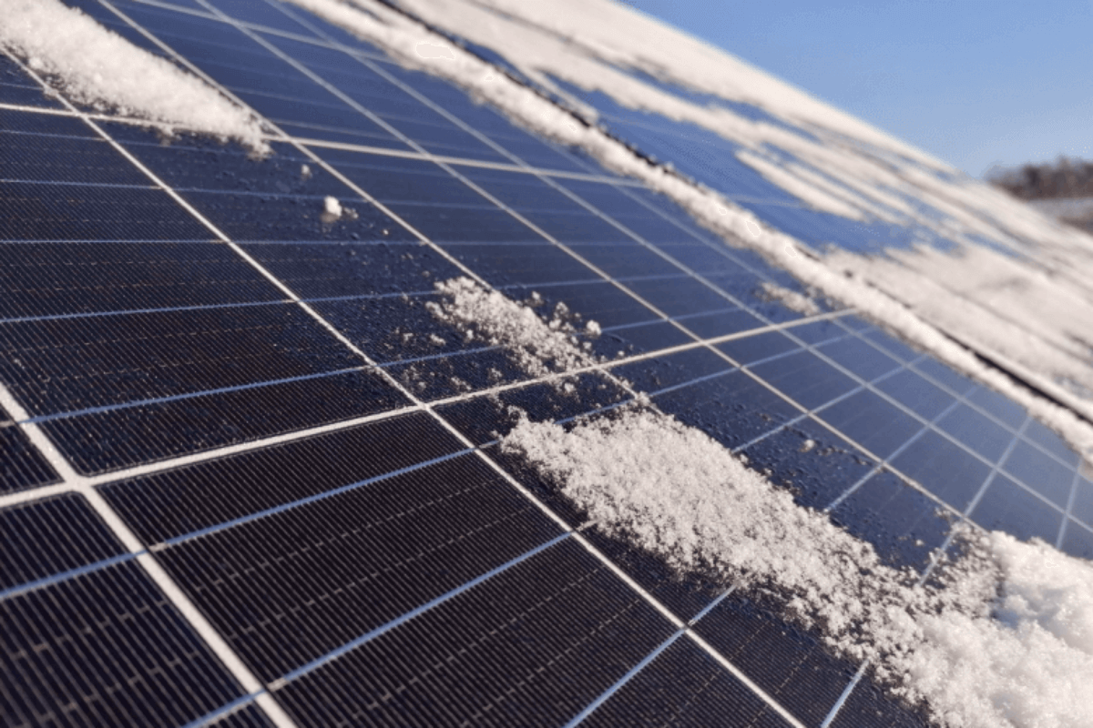 Zonnepanelen waarin de reflectie een licht bewolkte hemel te zien is.