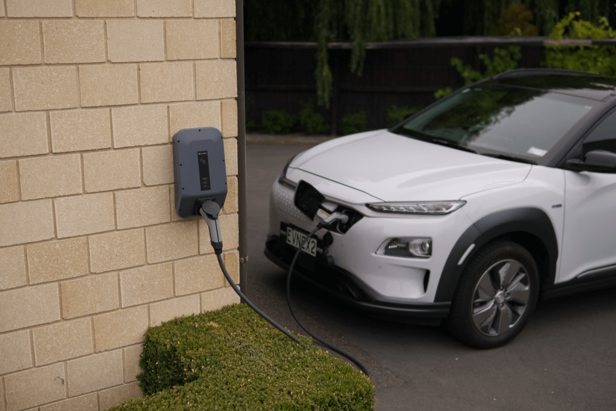 Elektrische auto is aan het opladen via een laadpaal aan de muur.